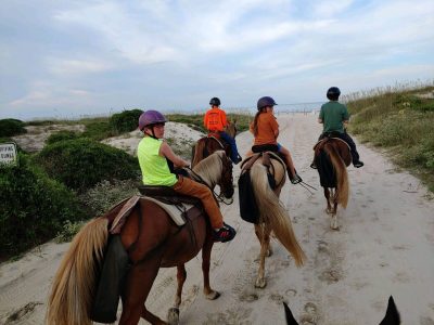 Family on beach horse ride